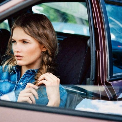 девушка плетет косу сидя на сиденье в машине