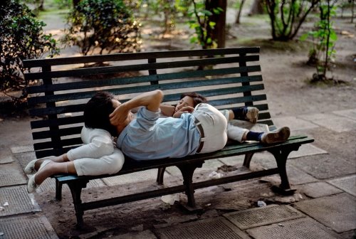 влюбленные лежат валетом на скамейке в парке