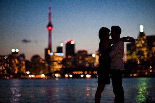 влюбленные обнимаются на фоне вечерних огней города
