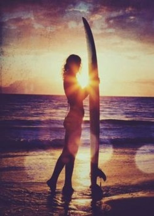 девушка серфингистка в лучах уходящего солнца