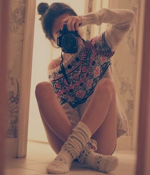 девушка фотографирует себя в зеркале сидя на полу