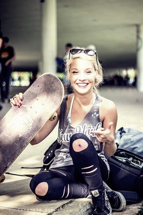 девушка показывает коленку со скейтом