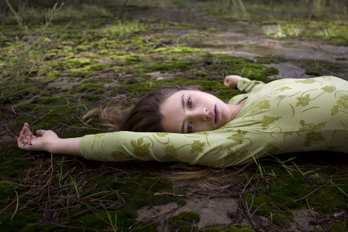 девушка лежит в траве в зеленой кофточке