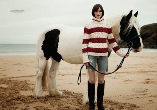 девушка держит за поводок белогривого коня