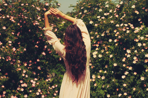 девушка в белом платье танцует среди цветущих деревьев