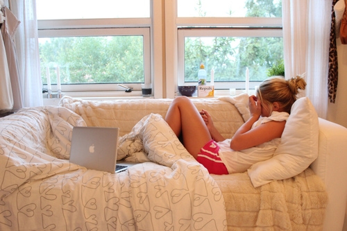 девушка лежит на диване у окна с ноутбуком эпл apple