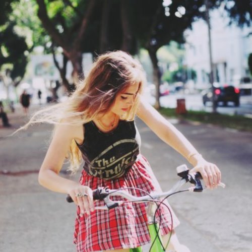 девушка в клетчатой юбке едет на велосипеде