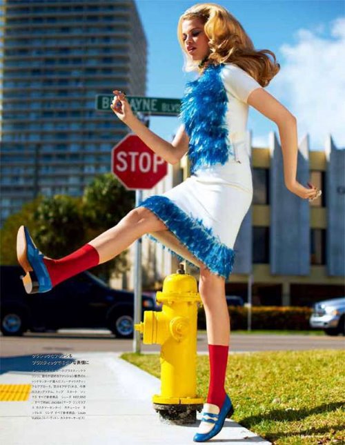 яркое фото девушки в белом платье с синим на фоне дорожного знака stop