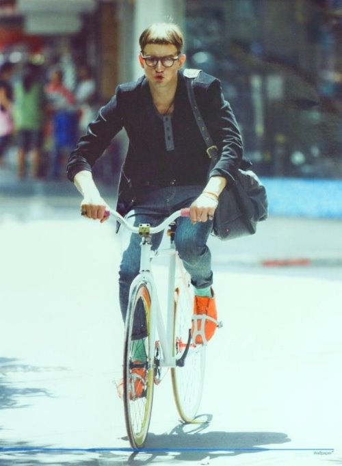 смешной парень едет на велосипеде по городу