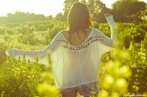 девушка спиной просвечивает солнцем белую кофту летом