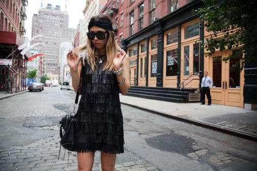 уличная мода девушка в черном платье с бахромой среди высоток