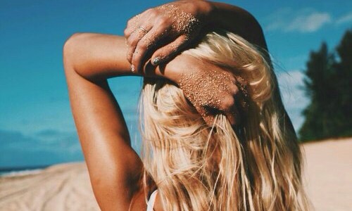 загорелая блондинка со спины на пляже
