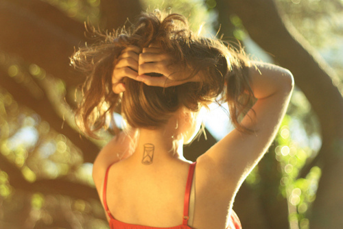 Татуировка песочные часы на спине у девушки