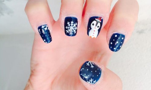 маникюр с пингвином и снежинками на синем лаке для ногтей
