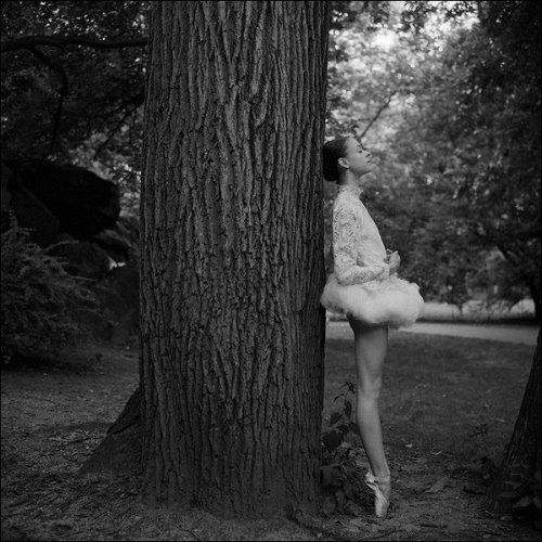 девушка подросток в юбке пачке стоит у дерева в лесу