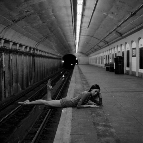 девушка лежит на перроне на животе свесив ноги к рельсам подъезжает метро
