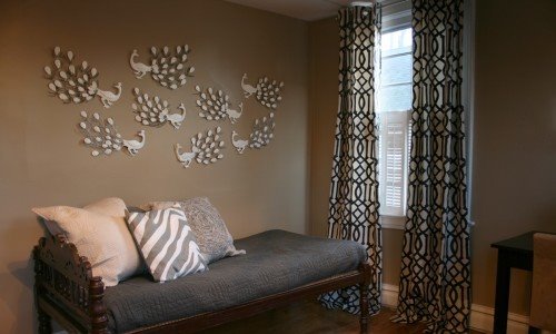 уютная комната в коричневых тонах с белыми павлинами на стенах