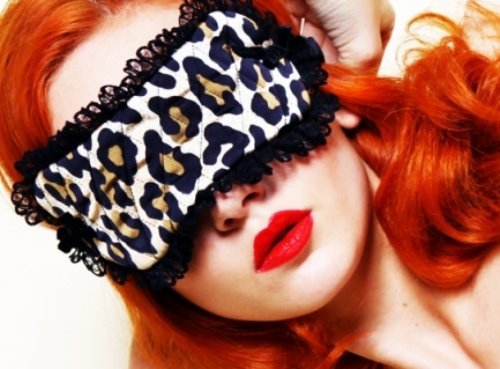 рыжая девушка с ярко красными губами в леопардовой маске с черными рюшами