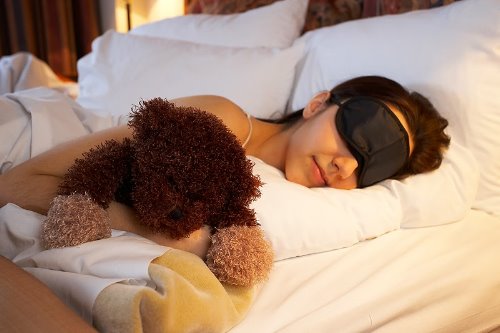 девчонка в черной повязке спит в обнимку с медведем игрушкой