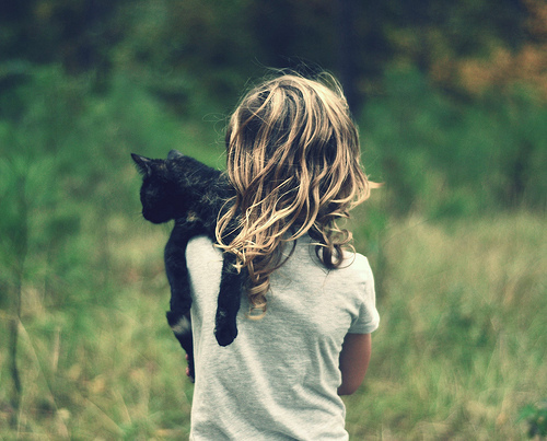 девочка в серой футболке с черным котёнком на плече с грязными волнистыми волосами