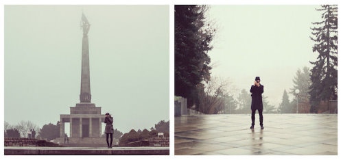 влюбленная пара снимает друг друга в туманный холодный день возле памятника и елей
