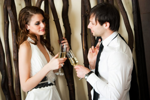 девушка и парень поднимают бокалы шампанского на корпоративе праздник