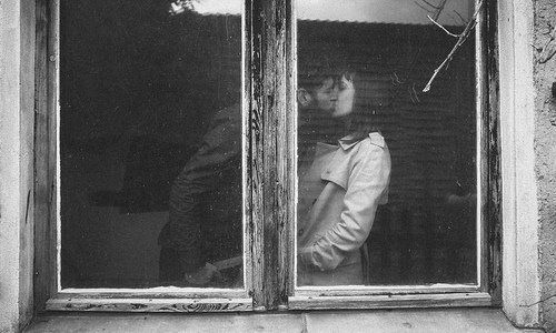 парень целует девушку в плаще в окне черно-белое фото в старом заброшенном здании