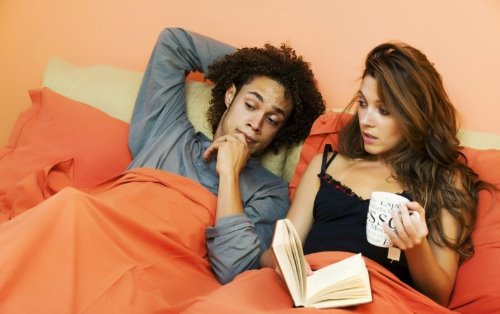 влюбленная пара в постели она читает книгу и пьет чай в пакетиках