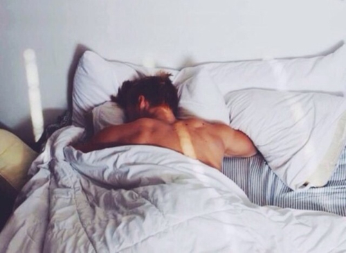 парень спит обняв подушку на него попадают лучи утреннего солнца