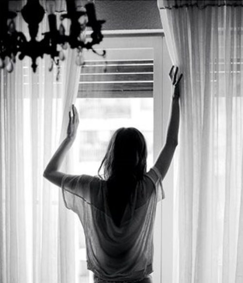Черно белое фото девушки открывающей окно