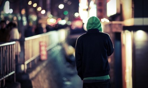 фото парня в куртке спиной по ночному городу в капюшоне