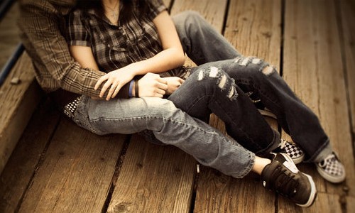 влюбленные сидят на деревянной лестнице в джинсах