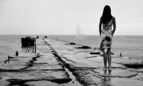 черно белое фото девушки спиной выглядывающей корабль в море