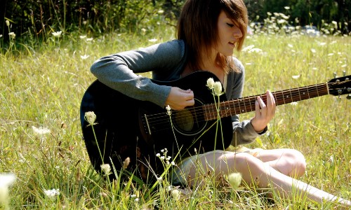 девушка поет играя на гитаре