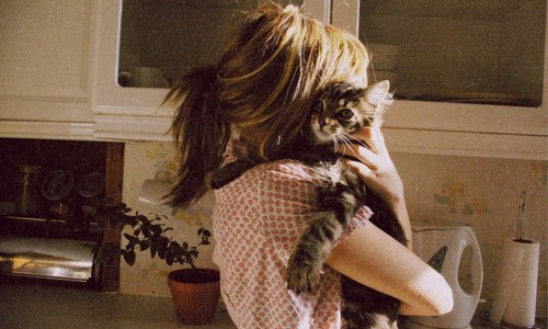  дівчина на кухні з смугастим кошеням на руках