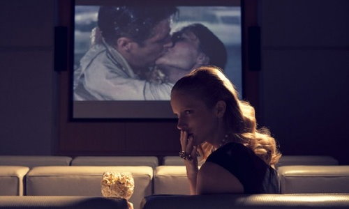 девушка в кинотеатре плачет во время сцены с поцелуем