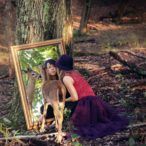девушка с олененком в лесу под деревом в зеркале