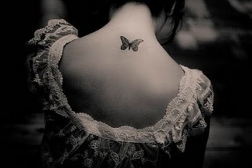 Девушка спиной с татуировкой бабочки на шее