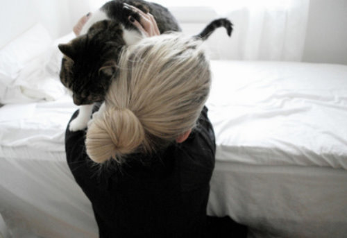 Блондинка со спины с радостью обнимает своего большого кота