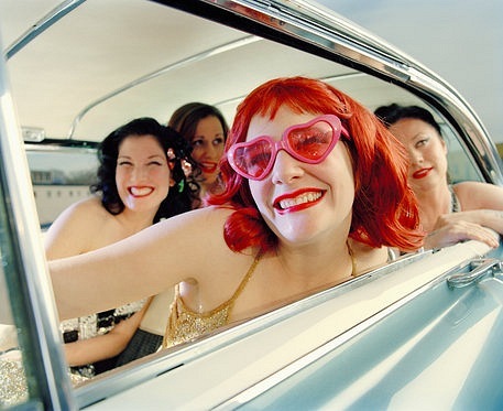 девушка в очках сердечках с подружками смеются в автомобиле