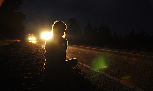 девушка сидит на дороге в свете фар ночью не видно лица силуэт