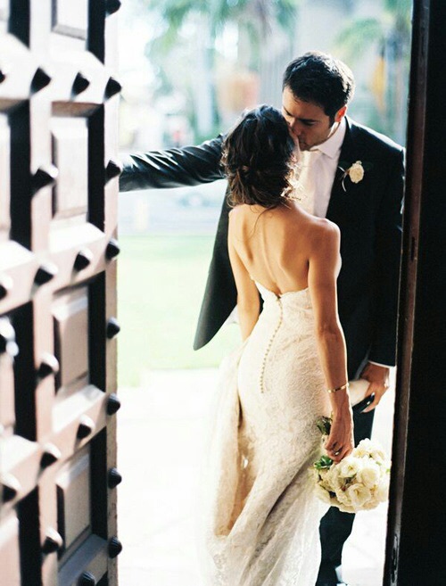 невеста со спины с букетом целует жениха