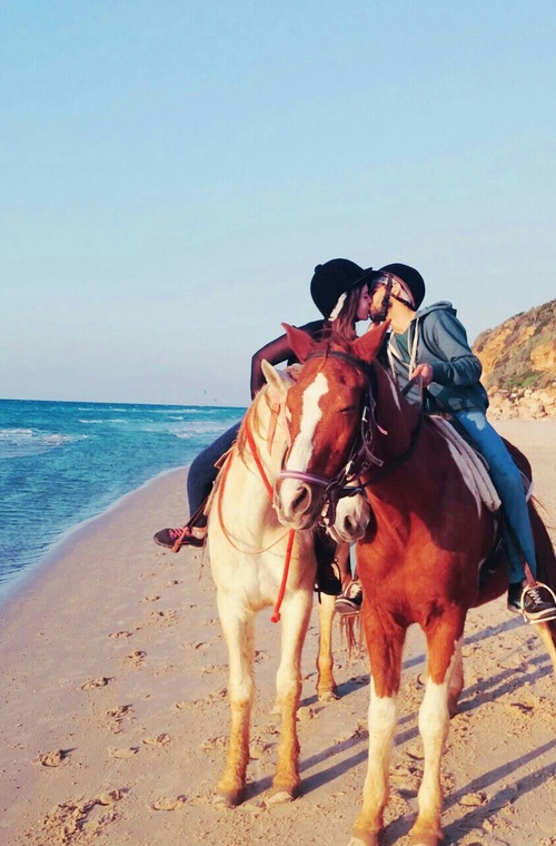 влюбленные на берегу моря целуются на лошадях