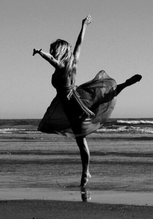 девушка в прозрачном платье танцует на берегу моря