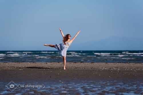 девушка в голубом платье танцует на море