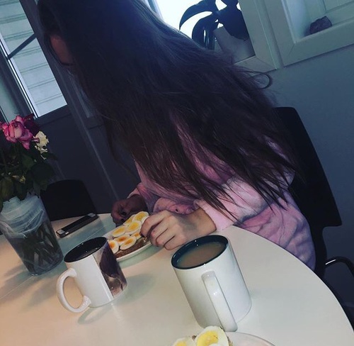 девушка в банном халате без лица завтракает за столом