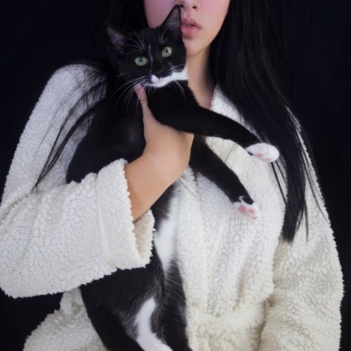 брюнетка с черным котом на руках в белом банном халате