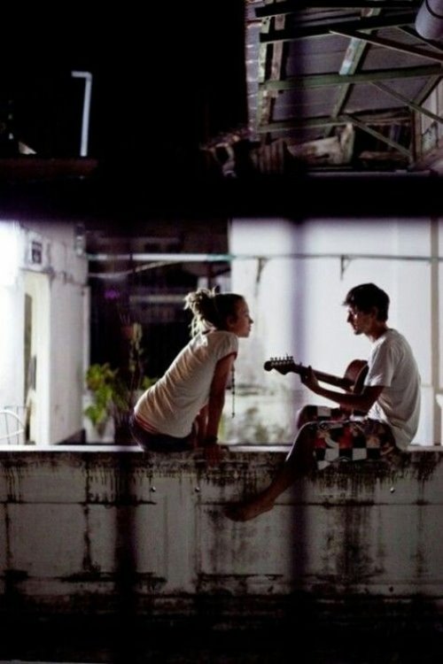 парень играет и поет девушке на гитаре ночью на крыше
