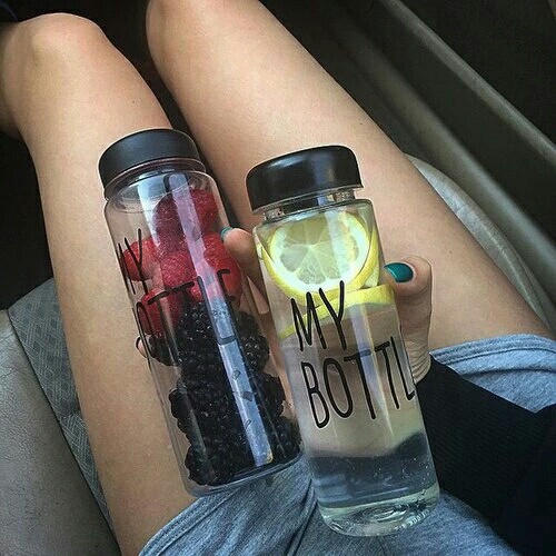 девушка с двумя бутылками май ботл в которым лимонная вода и ягоды