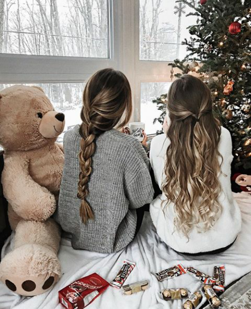 две подружки смотрят в окно на каникулах сидя под елкой